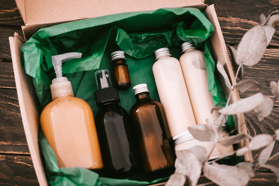 Beauty box with bottles of natural cosmetics, wrapped in green paper. Blogger hair and body care routine, salon treatments