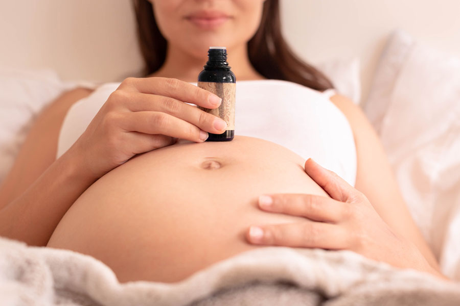 pregnant woman holding essential oil bottle